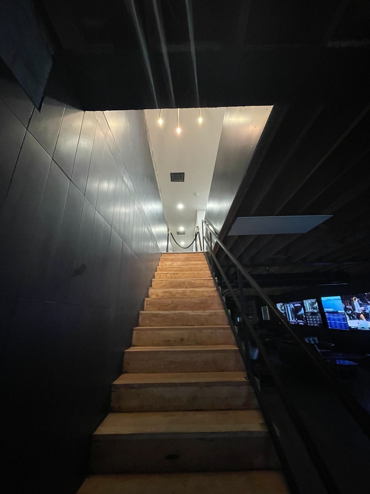 Wood staircase leading from the Prediction Vegas lounge to the private suites upstairs