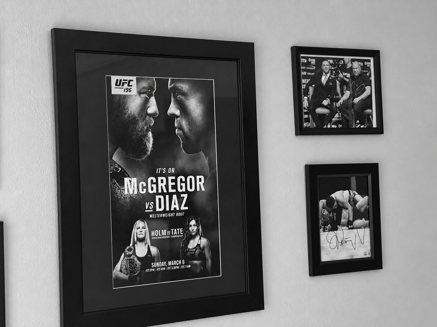 Black-and-white view of framed UFC fight poster and signed memorabilia displayed inside Prediction Vegas