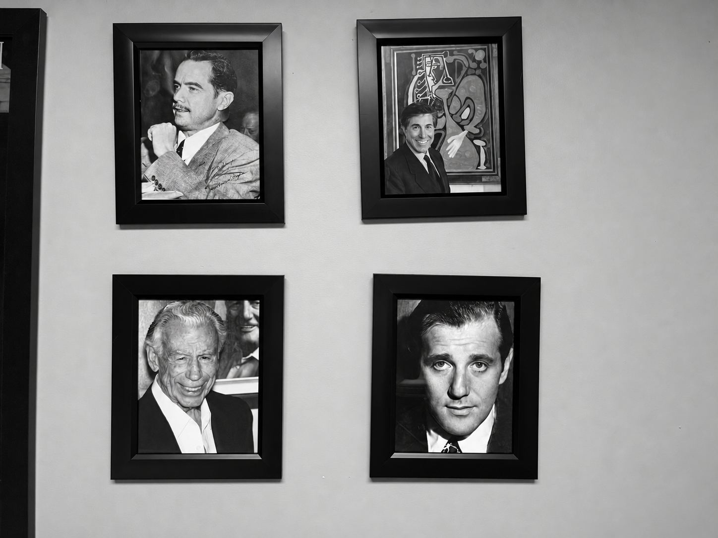 Black-and-white view of framed Las Vegas portraits and memorabilia displayed inside Prediction Vegas